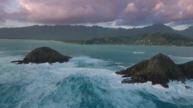 Kailua Oahu Adası, Hawaii Birleşik Devletleri. Pasifik Okyanusu 'ndaki küçük ada silueti. Hawaii tatili. Turizm arka planı 4K destansı gün doğumu. Na Mokulua Adalarına güneş doğarken düşen manzara dalgaları.
