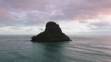 Gündoğumunda Mokolii Adası 'nı, arkasında Pasifik Okyanusu' nun sakinliğiyle yakın çekim yapın. Sinematik güzel sahil manzarası Hawaii 4K. Hawaii 'deki Oahu Adası. Manzaralı Çinlilerin Şapka Adası silueti