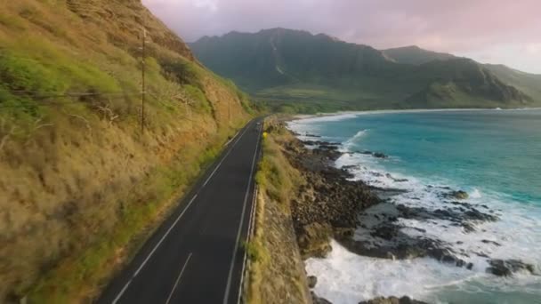 映画の海岸線に沿って空の道路 緑の火山の山々に向かって劇的な岩の海の海岸の上の道路 幸せな夏休みの背景 オアフ島の海辺を旅するハワイUsa — ストック動画