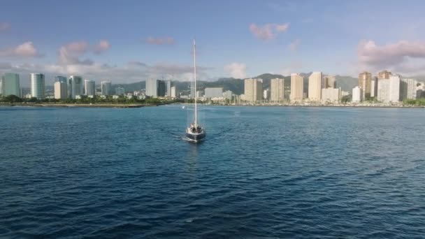 美しい景色を眺めながらサンセットクルーズを楽しむセーリング船の周りを飛ぶドローン 動きの背景水輸送 ハワイ州オアフ島の自然 K空中パノラマきれいな青い海ワイキキベイ — ストック動画