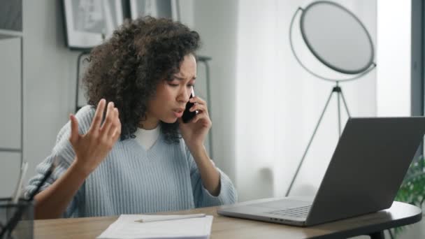 不满意的情绪激动的女人看着笔记本电脑屏幕 不满意的坏消息在电话4K大喊不 忧心忡忡的非洲裔美国女性移动用户通过智能手机听到了坏消息 — 图库视频影像
