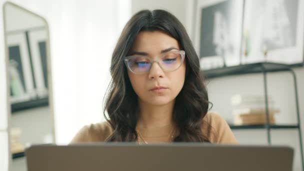 聪明的他的自由撰稿人女人 戴着眼镜在家里的电脑上工作 临时集中的年轻女企业家在家里的笔记本电脑上工作的同时开发新项目 商人慢吞吞的 — 图库视频影像