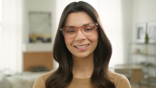 年轻的女专业教师笑得很积极 在线教育的概念 笑企业家远程在家工作 年轻快乐聪明的导师女人的画像 她穿着时髦的眼镜 看着相机 — 图库视频影像