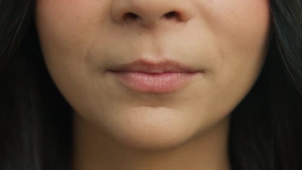 官能的な女性の閉鎖はゆっくりとした動きで豊満な唇をかむとなります 若い女性はセクシーな唇をかむと舌で舐める顔 魅力的な若い女の子の唇と口 健康な白い歯 皮膚の顔 — ストック動画