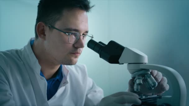 연구소 제복을 엔지니어를 합니다 과학자인 현미경을 사용하여 실험을 생물학 실험실의 — 비디오