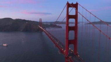 Alacakaranlıkta Golden Gate Köprüsü 'nün gün batımı manzarası ve karanlık gökyüzünde pembe bulutlar. Golden Gate Ulusal Rekreasyon Bölgesi 'nin San Francisco, Kaliforniya' daki hava manzarası. Sahne doğası