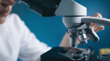 Modern tıp laboratuarında mikroskop kullanarak DNA mutasyonlarını inceleyen bir kadın. Mikroskop analizinde çalışan bir mikrobiyolog. Yüksek Teknoloji Ekipmanı 'nda çalışan bilim adamı.