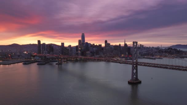 三藩市天际线和海湾大桥在美丽的落日下的空中美景 电影戏剧性的日落天空 粉色的云彩在旧金山市中心上空 美国市中心的景观4K — 图库视频影像