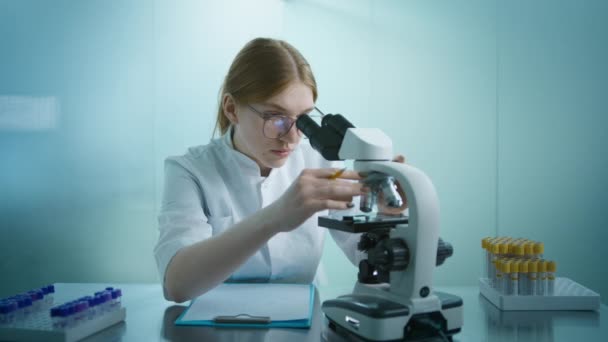 从事病毒疫苗或基因治疗医学显微镜的专业生物化学家 医学实验室的慢动作 专业生物技术女科学家开发药物 — 图库视频影像