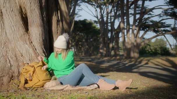 森の中をトレッキングする白人ハイカーの女性 若い幸せなバックパックの女の子の地図とツリーでは 道路の旅を楽しんで座っている 旅行自然アドベンチャー アウトドア 秋または春の休暇のコンセプト — ストック動画
