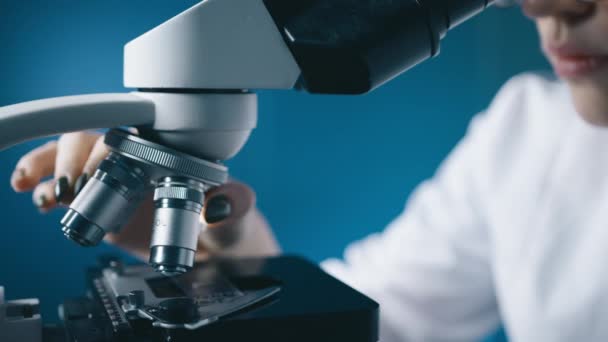 Dna検査の結果を行う女性は 現代科学研究所でヒト疾患からワクチンを開発する 顕微鏡分析サンプルを扱う微生物学者 ハイテク機器を扱う科学者 — ストック動画