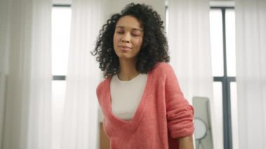 Beyaz dişli gülümseyen kameraya gülen neşeli genç Afrikalı kadının yavaş çekim portresi. Zevkli, siyah, modaya uygun, renkli, genç bir kadın. Mutlu portre, gerçek insanlar.