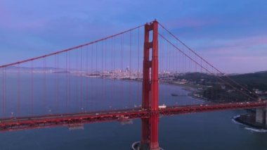 San Francisco Körfezi 'ndeki Golden Gate Köprüsü' nün havadan görüntüsü. ABD 'nin simgesel kırmızı asma köprü mimarisi. San Francisco şehir merkezindeki gece manzarası. Gün batımı manzarası 4K.