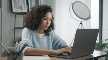 Modern teknoloji aygıtı üzerinde çalışan serbest çalışan meşgul bir işçi. Bilgisayarda araştırma yapan odaklı iş kadını girişimci. Karışık ırktan profesyonel bir bayan bilgisayar kullanıyor ve ofis masasında oturuyor.