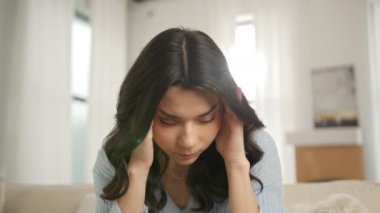 Mutsuz genç Latin kadının portresi, tapınakları ovuyor, acı verici baş ağrısı çekiyor. Kronik migren ağrısı çeken bir kız. Ayrılma ve boşanma, zor dönem konsepti ağır çekim 4K