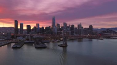 San Francisco şehir merkezinde pembe bulutlu dramatik günbatımı gökyüzü. 4K manzaralı bir Amerikan şehri. San Francisco City Skyline ve Bay Bridge 'in nefes kesen güzel günbatımının hava manzarası.