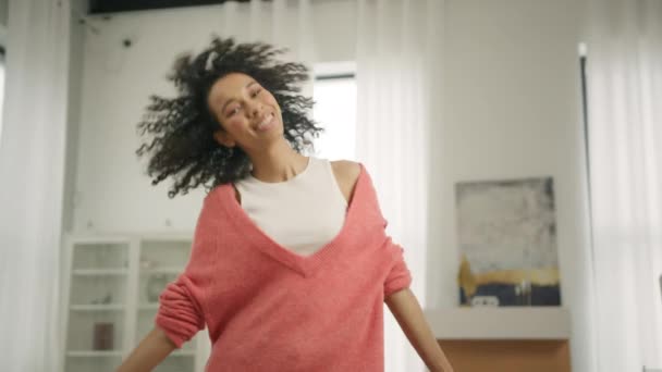 身穿粉色珊瑚毛衣的活跃的非洲黑人妇女在现代阁楼公寓的背景下跳舞 酷才华横溢的混合型女舞蹈家 对流行音乐有节奏地自由舞动 拍击4K — 图库视频影像