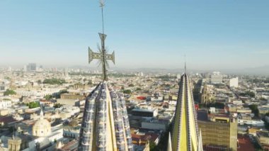 Guadalajara Katedrali 'nin tepesindeki kulede zarif neo gotik mimari stili haçın yakın görüntüsü. Lens ışığıyla parlayan altın güneş. Guadalajara Havayolları Ufuk çizgisi Meksika