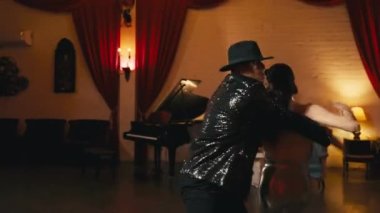 Klasik tiyatro içinde dans eden ince yapılı Asyalı güzel bir kadın. Göz kamaştırıcı çift akrobatik sicim hareketi yapıyor. Funk tarzı dans eden Asyalı profesyonel dansçı erkek 4K ile dans ediyor.
