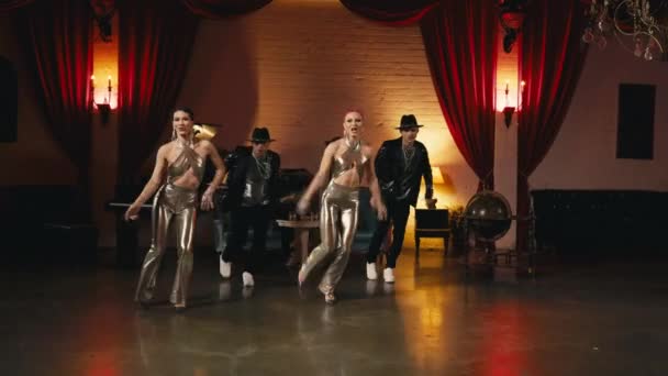 令人印象深刻的表演在迷人的时尚好莱坞风格的夜总会 团体舞蹈演员移动同步编舞 穿着金色时髦服装的时髦现代职业舞蹈家动作缓慢 — 图库视频影像