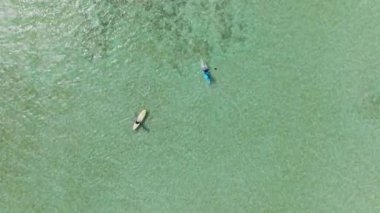 Oahu, Hawaii adası ABD 'de sığ sularda yemek masasında kürek çeken iki kadının videosu. Turistlerin yaz tatillerinde su sporundan keyif aldıklarını gösteren hava manzarası. Aktif turizm ve seyahat kavramı