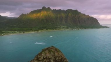 Mokolii Adası 'nın arka planında Kualoa çiftlik manzarası olan havadan görünüşü, Hawaii Oahu adası. Yeşil Porselen Adam Şapka Adası 'nın insansız hava aracı görüntüsü. Havai 4K 'nın sinematik, güzel kıyı manzarası.