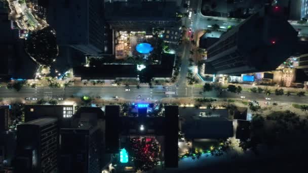 ワイキキのホテルビルでの車のトラフィックの美しいトップビュー 夜の街の上空4Kドローン 都市の街並みの概念は 観光事業の概念 ホノルルのダウンタウンのナイトライト オアフ島 アメリカ — ストック動画