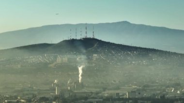 Meksika, Guadalajara 'da iklim acil durumu. İklim değişikliği, küresel ısınma, Meksika şehir merkezinde ve çevresindeki banliyölerde güneş doğarken 4K insansız hava aracı görüşü üzerinde sallanan duman ve kirliliğin destansı manzarası.