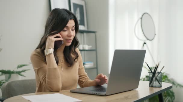 积极的拉丁女性客户打电话确认网上购物订单递送的概念 在家里的写字台上 一个年轻的惊慌的女商人正在用笔记本电脑打电话 — 图库视频影像