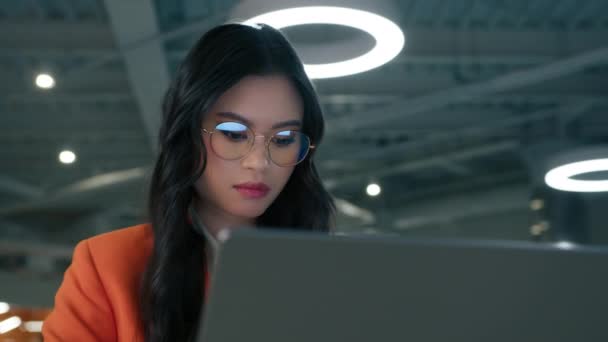 ラップトップで作業しながら新しいプロジェクトを開発する若い女性起業家に集中しました ビジネスパーソン4K ロフトデザインオフィスでコンピュータ上で作業眼鏡のスマートアジア民族ビジネス女性 — ストック動画
