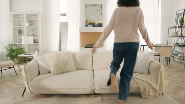 Fröhliche Afroamerikanerin Die Allein Barfuß Auf Dem Sofa Modernen Wohnzimmer — Stockvideo