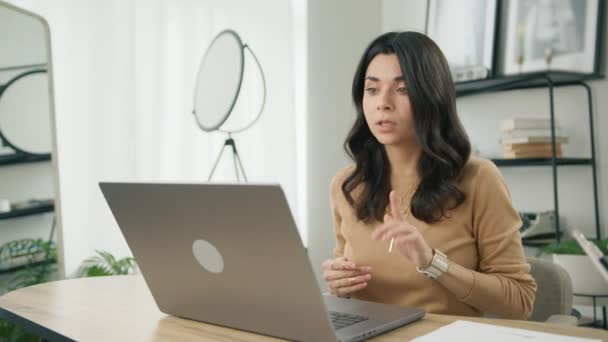 愤怒的拉丁裔女商人在视频通话中对着网络摄像头直言不讳地挥手 焦虑的紧张女孩在家里用手提电脑工作 商人在线技术4K — 图库视频影像