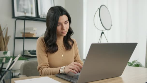 忙着研究现代技术设备的自由职业者 重点研究了他的恐慌女企业家在笔记本电脑上打字的情况 使用电脑坐在家庭写字台的拉丁女性专业人员 — 图库视频影像