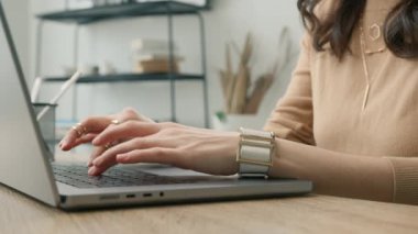 Not defteri kullanan profesyonel kullanıcı. Teknoloji konsepti 4K 'yi kapat. Dizüstü bilgisayarda yazı yazan iş kadınının elleri ofis masasında oturup bilgisayar uygulamalarıyla çalışıyor.