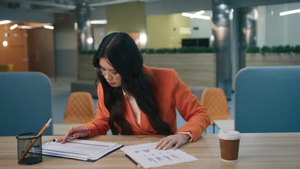 아시아인 매니저는 사무실에서 밤늦게 열심히 일하면서 보고서 테이블을 기진맥진 아시아 — 비디오