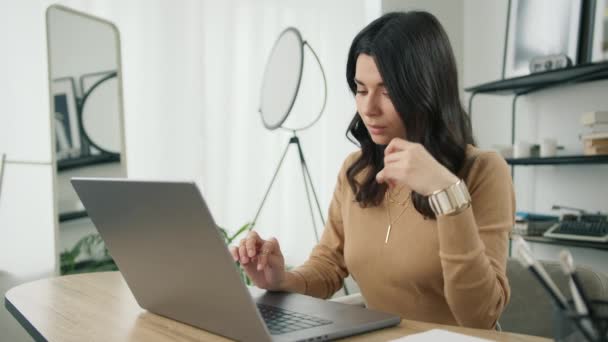 重点研究了他的恐慌女企业家在笔记本电脑上打字的情况 拉丁女性专业使用电脑坐在家里的写字台 忙着研究现代技术设备的自由职业者 — 图库视频影像