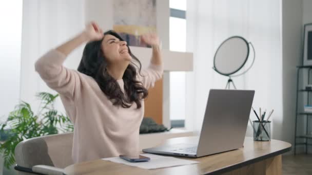 快乐快乐的拉丁女企业家 远程家庭办公概念背景 笑笑他的惊慌失措的女商人坐在电脑前工作 拉丁女孩一边跳舞一边看令人兴奋的新闻邮件 — 图库视频影像