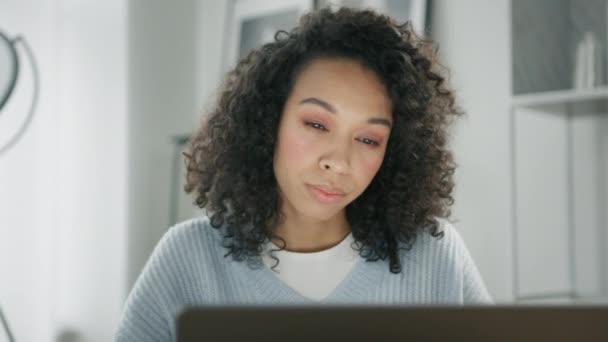 アフリカ系アメリカ人女性起業家はオンラインプロジェクトの分析やデジタルデータの資金調達を考えている 4Kを閉じます 若い集中混合人種のビジネス女性は ラップトップのコンピュータ画面を見て作業 — ストック動画