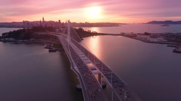 美国航机4K现代悬索桥建设中的交通 背景为美丽的阳光 在美丽动人的玫瑰金色落日的映衬下 飞越了海湾大桥的白塔 飞越了旧金山湾 — 图库视频影像