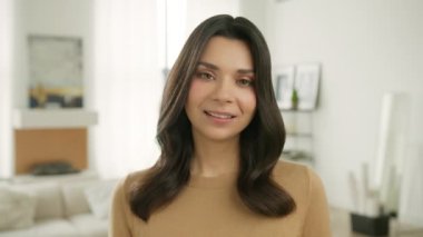 Yüz ifadeleri serisi. Yakından neşeli bir kız kameraya bakıyor ve gözleriyle flört ediyor. Şehvetli, güzel bir kadın dudaklarını ısırıyor erotik bir tahrik ifadesi sergiliyor. Modern dairede güzel bir kadının portresi.