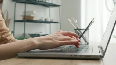 Teknoloji konsepti 4K 'yi kapat. Dizüstü bilgisayarda yazı yazan iş kadınının elleri ofis masasında oturup bilgisayar yazılım uygulamalarıyla çalışıyor. Not defteri kullanarak yan görünüm profesyonel kullanıcı çalışanı