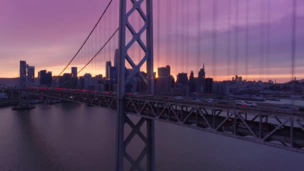 샌프란시스코만을 가로지르는 브릿지의 차량들 공중에서 촬영되었습니다 샌프란시스코 시내에서 분홍색으로 구름낀 — 비디오