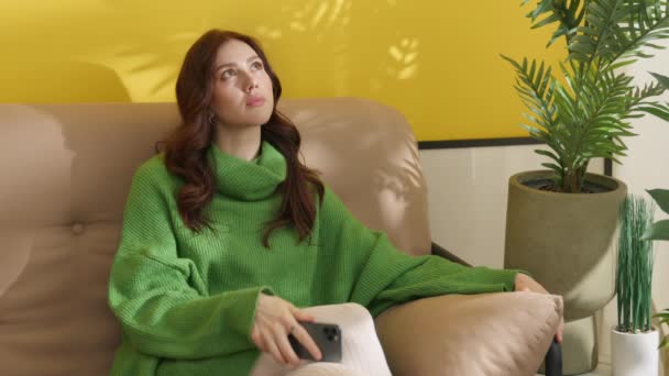 Belle Jeune Brune Réfléchie Assise Sur Canapé Avec Smartphone Tapant — Video