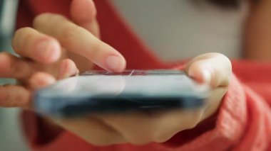 Mobil uygulamalı cep telefonu cihazındaki sinema sayfalarını kapat. İnternette film izlemek için internet kütüphanesinde video izliyorum. Ağır çekim kadın parmakları modern akıllı telefon ekranına dokunuyor
