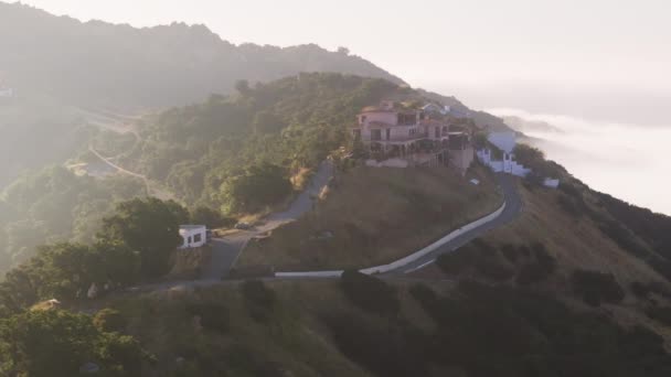 空中俯瞰无人驾驶飞机在青山山顶上昂贵的豪宅周围飞行 在运动的背景下 在日出时分 云彩密布 山顶4K周围的电影云彩 — 图库视频影像