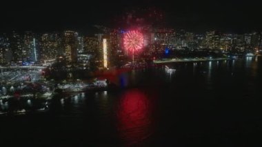 Waikiki gökyüzünde havai fişek gösterisi. Honolulu 'da yeni yıl arifesi. İnsanlar Hawaii tatili sırasında Oahu adasında havai fişeklerle kutlama yapıyorlar. Şehir siluetinde parlak havai fişek patlaması