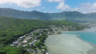Manzaralı mercan resifi kıyısındaki küçük Kahaluu sahil kasabasının havadan görünüşü. Hawaii adasında yaz tatili. İnsanlar yaz tatilinde Hawaii 'de su sporlarının keyfini çıkarıyorlar. 4K ABD turizmi.