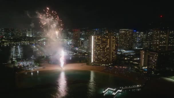 ホノルル市の大晦日 ハワイの休暇中にオアフ島で輝く花火で祝う人々 都会のスカイラインで花火の明るい爆発 空中ビュー花火 ワイキキビーチ — ストック動画