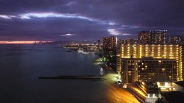 Alacakaranlıkta sahil Bay City 'nin güzel şehir manzarası. Hawaii Adası 4K 'da şehir ışıkları. Gün batımından sonra Waikiki sahilinde. Manzaralı Honolulu gökyüzü manzarası. Oahu şehrinin gece manzarası