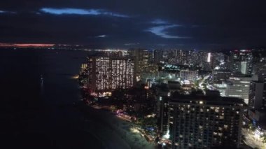 Sahne gün batımında Honolulu silueti aydınlandı. Hava Oahu şehri, gece sahnesinde. Alacakaranlıkta sahil Bay City 'nin güzel şehir manzarası. Hawaii adasındaki şehir ışıkları. Gece Waikiki sahilinde.